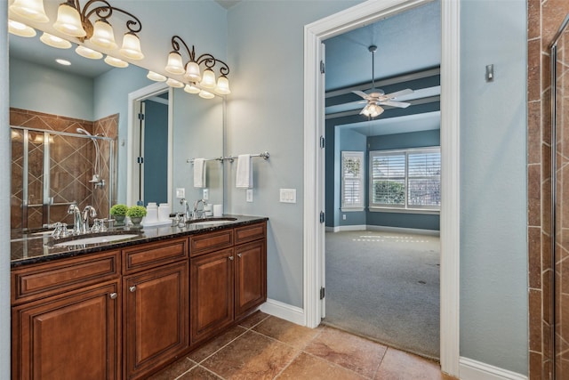 bathroom with vanity, a shower with shower door, and ceiling fan