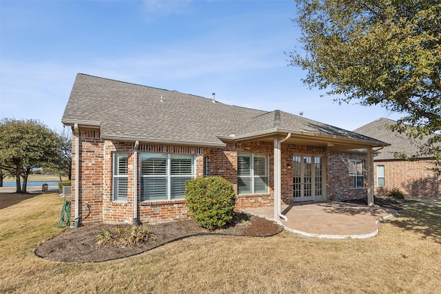 rear view of property with french doors, a yard, and a patio area