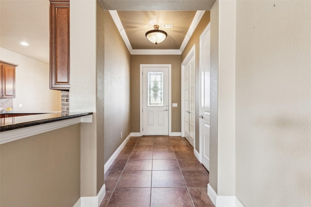 doorway to outside featuring dark tile patterned floors and crown molding