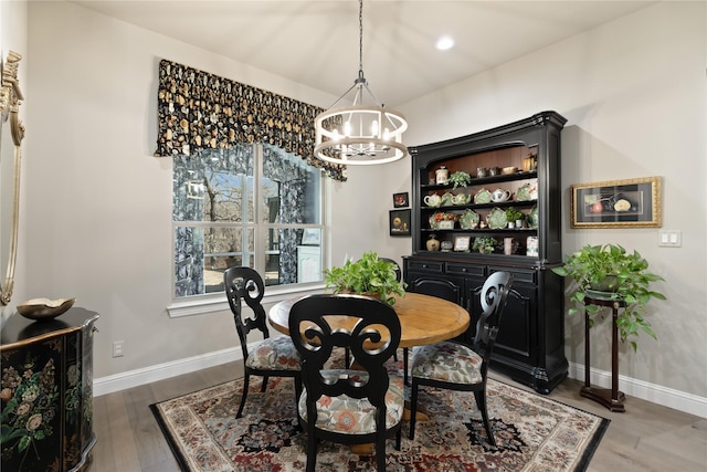 dining space with wood-type flooring and an inviting chandelier