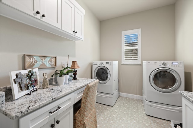 washroom featuring cabinets and washer and clothes dryer