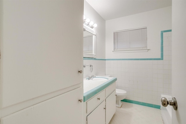 bathroom featuring tile patterned flooring, vanity, tile walls, and toilet