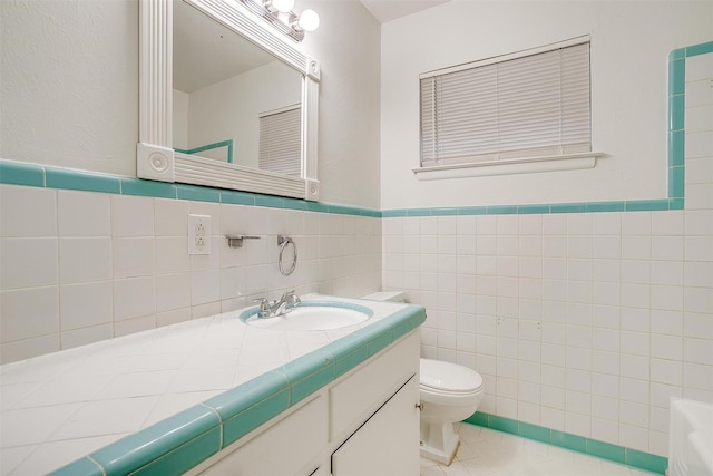 bathroom featuring tile patterned floors, toilet, tile walls, and vanity