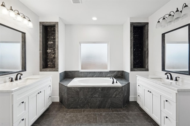 full bathroom featuring two vanities, tile patterned flooring, a sink, and a bath