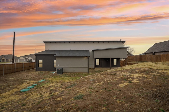 exterior space with cooling unit, a fenced backyard, and stucco siding