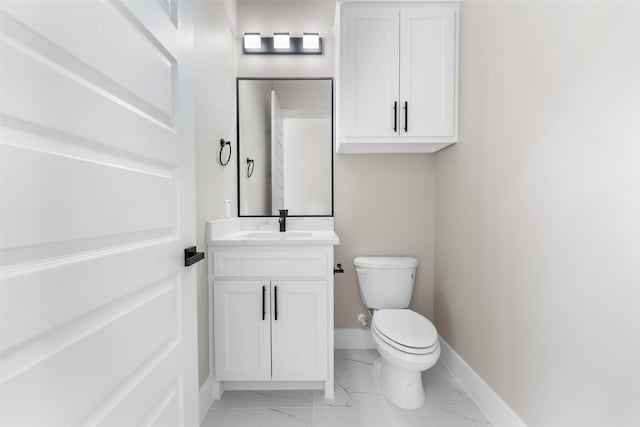 bathroom with toilet, marble finish floor, baseboards, and vanity