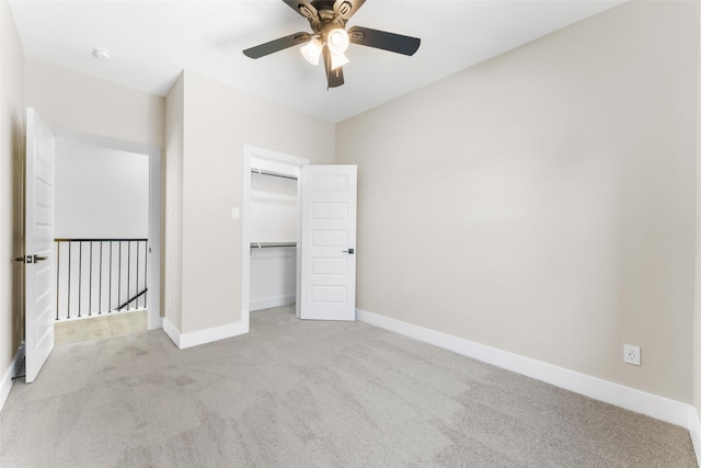 unfurnished bedroom featuring carpet floors, a ceiling fan, baseboards, and a closet