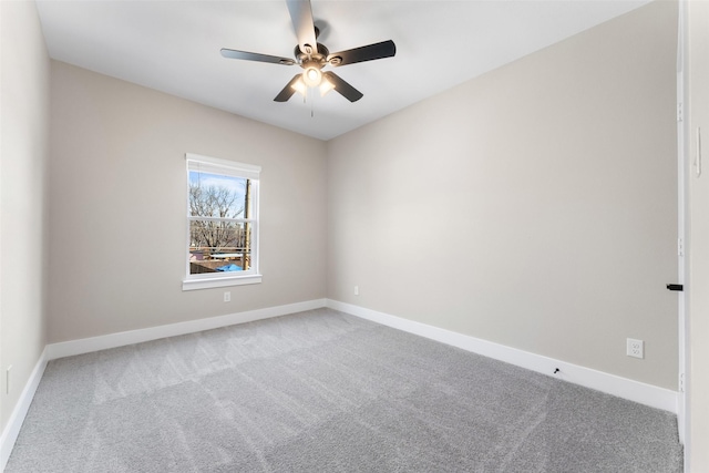 carpeted empty room featuring ceiling fan and baseboards