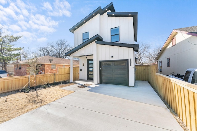 view of front of house with driveway, a garage, fence, and board and batten siding