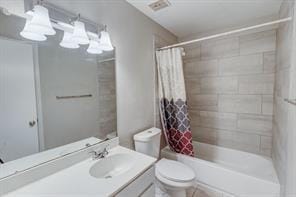 full bathroom with vanity, shower / tub combo, and toilet