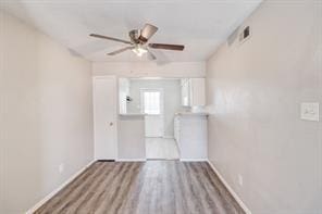 empty room with ceiling fan and light wood-type flooring