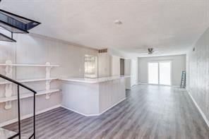 kitchen featuring crown molding, wood-type flooring, and kitchen peninsula