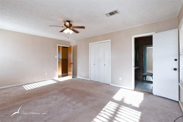 unfurnished bedroom with light colored carpet, a textured ceiling, and ceiling fan