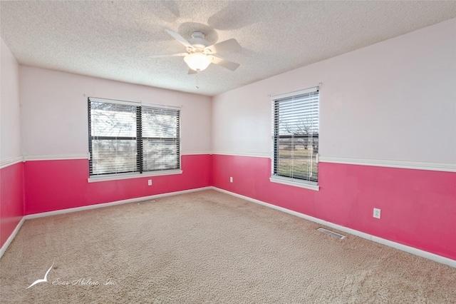 carpeted empty room featuring ceiling fan and a textured ceiling