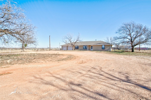 exterior space with a garage and a rural view