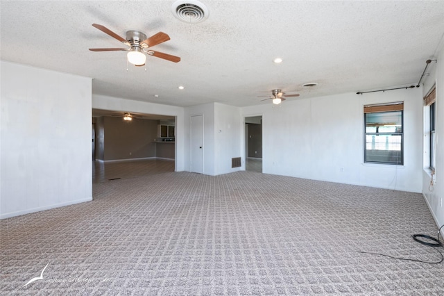 spare room featuring ceiling fan, a textured ceiling, and carpet