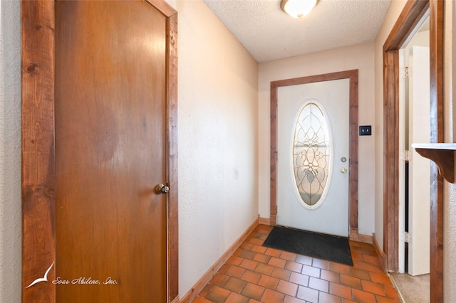 doorway to outside with a textured ceiling