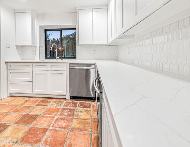 kitchen with tasteful backsplash, white cabinets, sink, and dishwasher