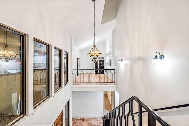 stairs featuring an inviting chandelier and vaulted ceiling