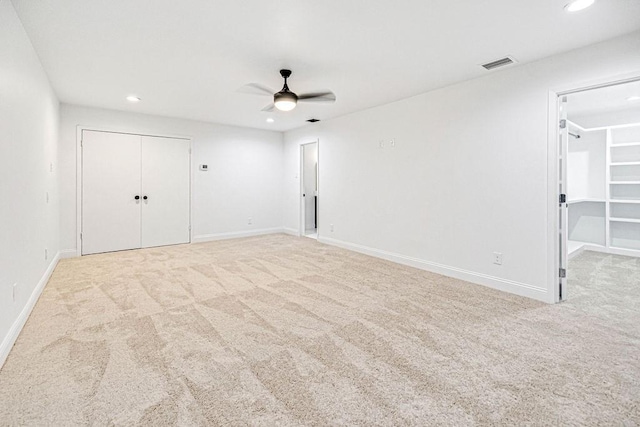 unfurnished bedroom featuring light carpet, ceiling fan, and a closet