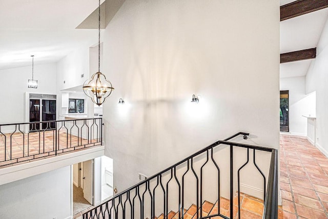 staircase featuring lofted ceiling with beams and an inviting chandelier