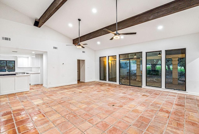 unfurnished living room featuring beamed ceiling, ceiling fan, sink, and high vaulted ceiling