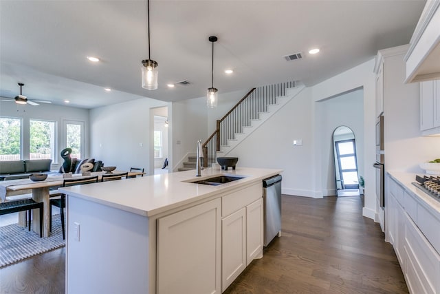 kitchen with sink, stainless steel appliances, an island with sink, and white cabinets