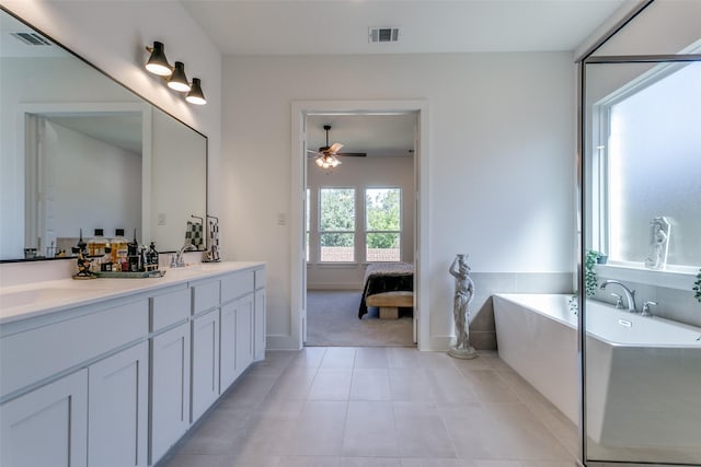 bathroom featuring ceiling fan, a tub to relax in, vanity, and tile patterned flooring