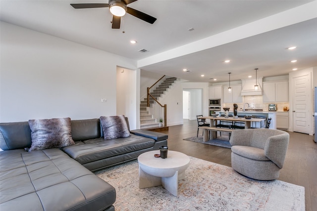 living room featuring ceiling fan, sink, and light hardwood / wood-style flooring