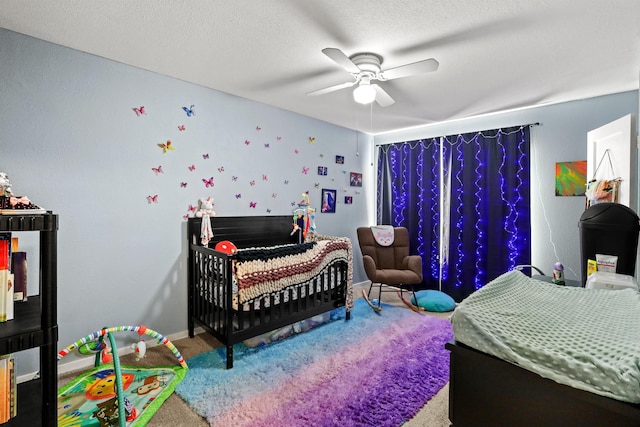 bedroom featuring a textured ceiling, carpet floors, and ceiling fan