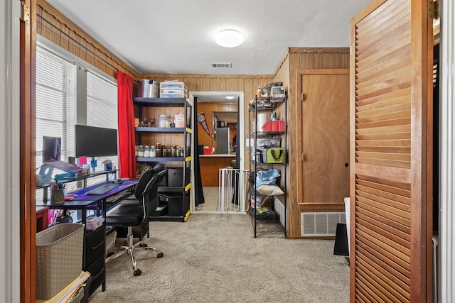 home office featuring light carpet and wood walls