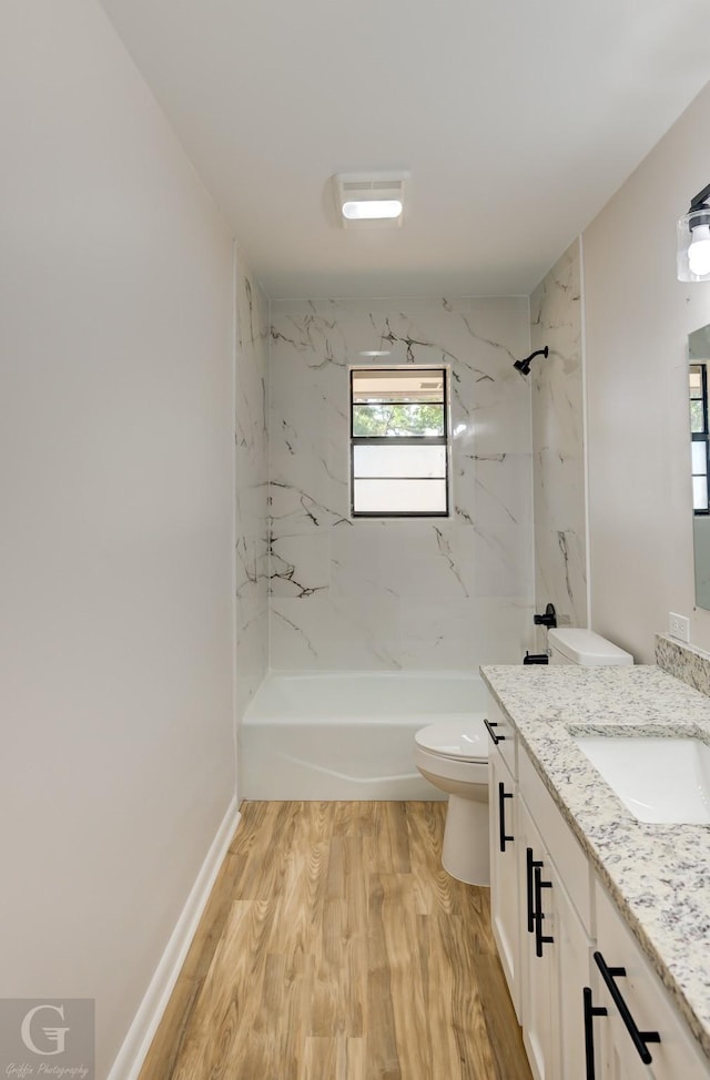 full bathroom featuring tiled shower / bath, wood-type flooring, toilet, and vanity