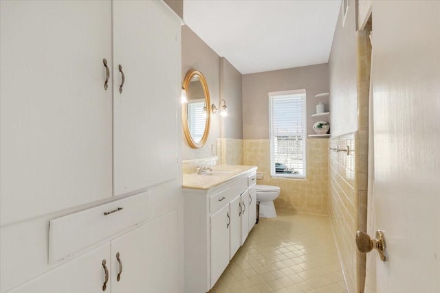 bathroom with vanity, toilet, tile patterned flooring, and tile walls