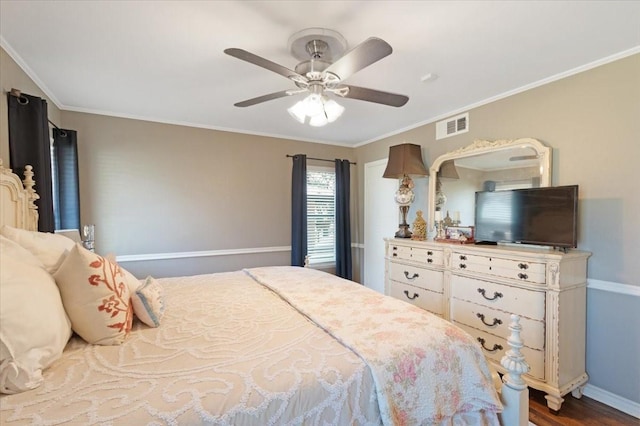 bedroom with a ceiling fan, visible vents, baseboards, ornamental molding, and dark wood finished floors