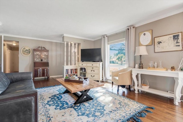 living area with crown molding, baseboards, and wood finished floors