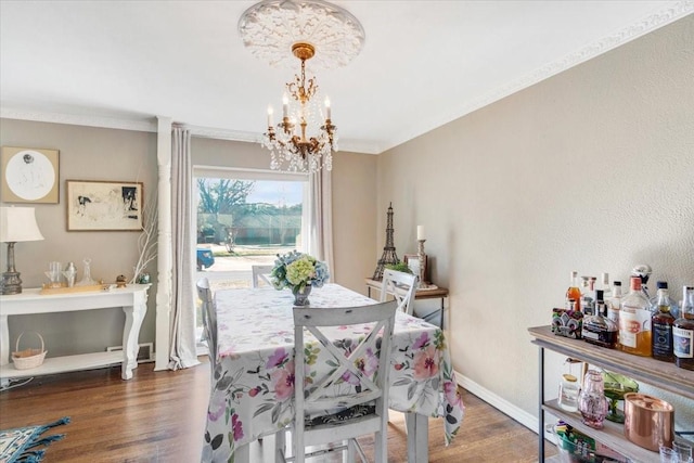 dining space with an inviting chandelier, crown molding, and dark hardwood / wood-style floors