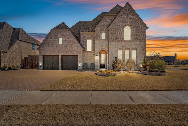 view of front of house with a garage and a yard