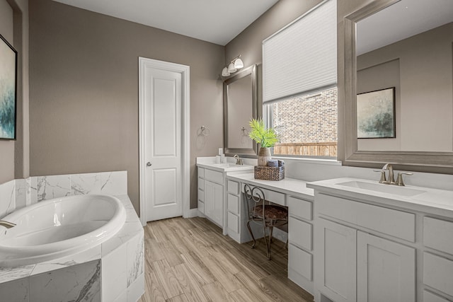 920 Windrock Ln, Prosper, TX 75078 - bathroom with double vanity, a garden tub, and wood finished floors