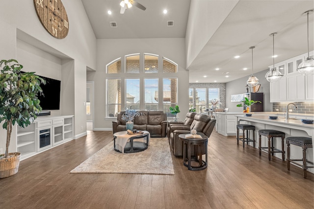 920 Windrock Ln, Prosper, TX 75078 - living area featuring dark wood-style flooring, a ceiling fan, a towering ceiling, baseboards, and recessed lighting