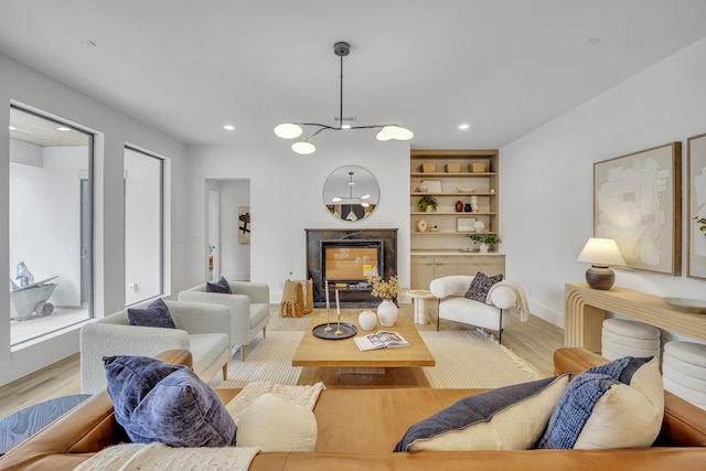 living room with light hardwood / wood-style flooring and built in features