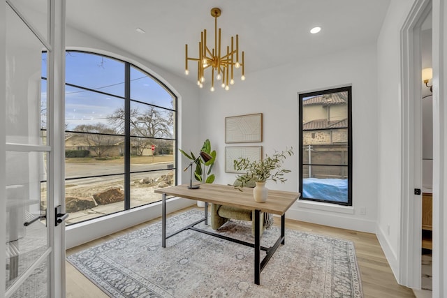 office area featuring an inviting chandelier, plenty of natural light, and light hardwood / wood-style flooring