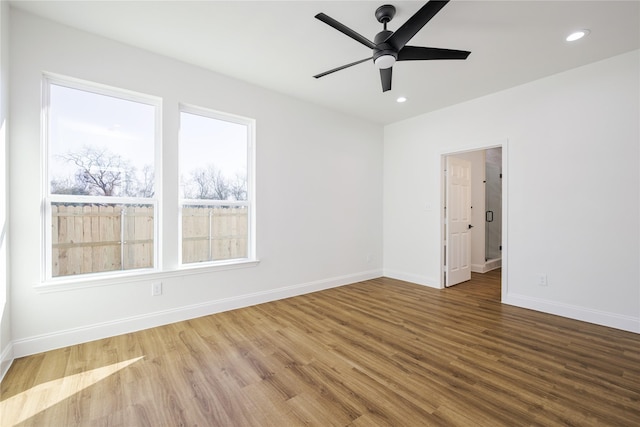 spare room featuring hardwood / wood-style flooring, ceiling fan, and plenty of natural light