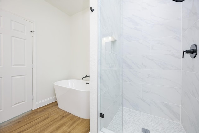 bathroom featuring wood-type flooring and shower with separate bathtub