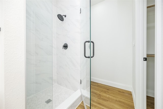 bathroom featuring hardwood / wood-style flooring and walk in shower