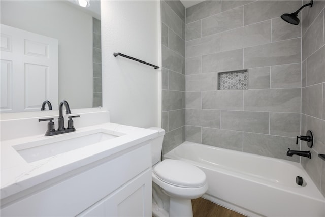 full bathroom featuring vanity, hardwood / wood-style flooring, toilet, and tiled shower / bath