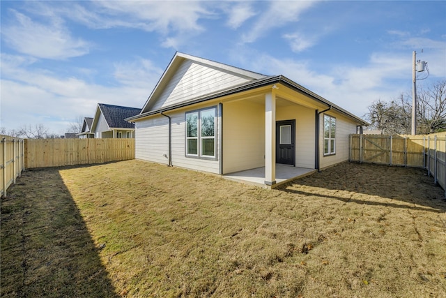 rear view of house with a patio area and a lawn