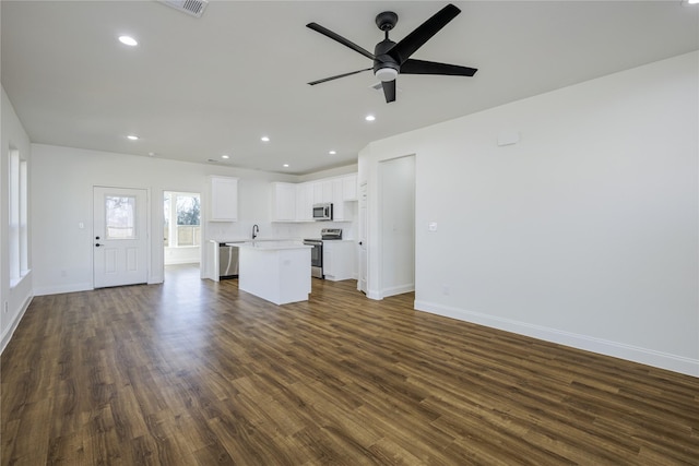 unfurnished living room featuring dark hardwood / wood-style floors, sink, and ceiling fan