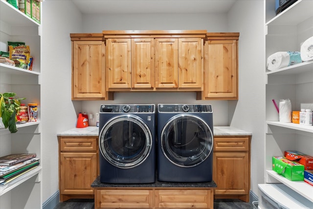 clothes washing area featuring washer and clothes dryer and cabinets