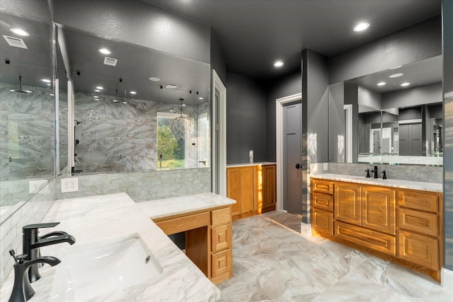 bathroom with tiled shower and vanity