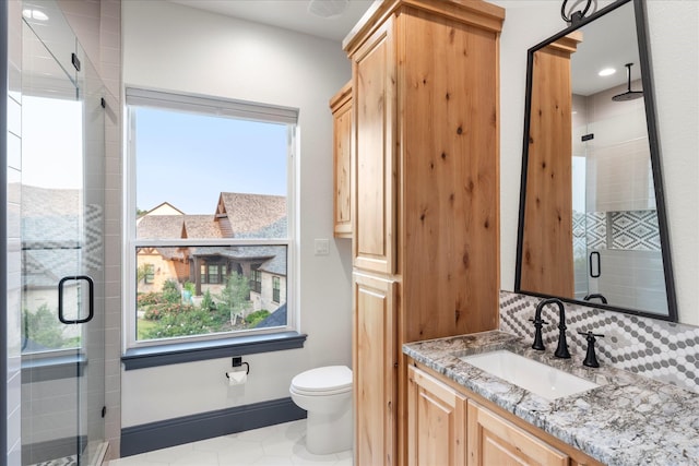 bathroom featuring vanity, toilet, and a shower with shower door